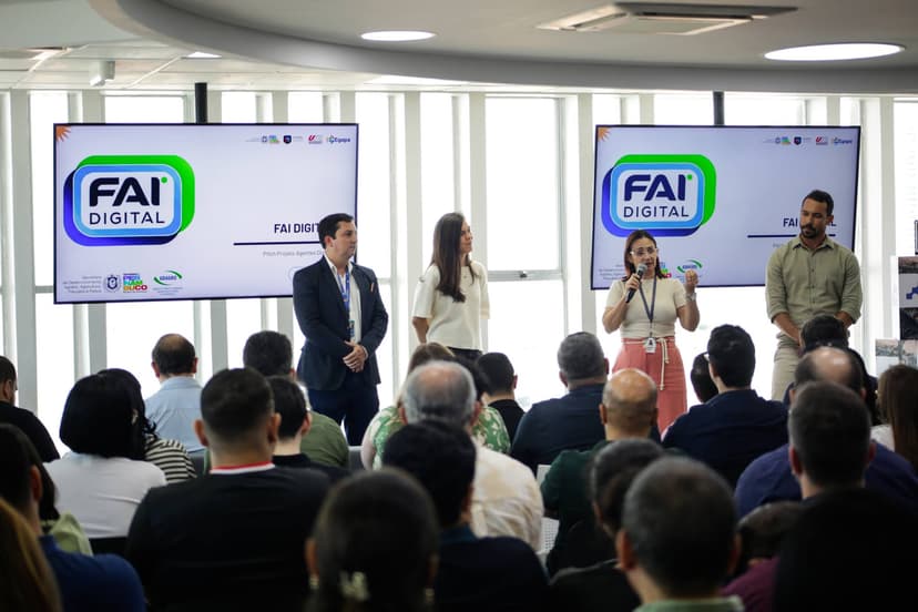 Apresentação no evento FAI Digital com palestrantes no palco e tela exibindo o logotipo do programa.